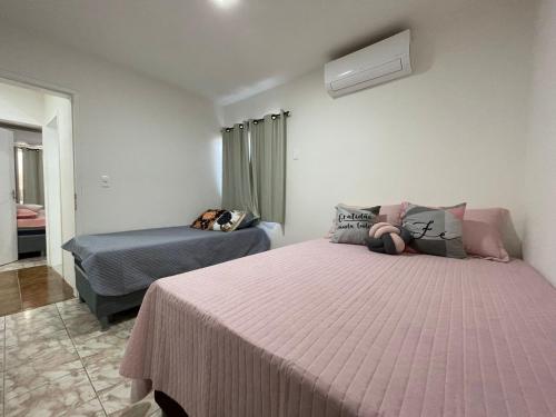 - une chambre avec 2 lits et une couverture rose dans l'établissement Apartamento em Maceió, à Maceió