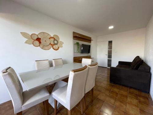 une salle à manger avec une table et des chaises blanches dans l'établissement Apartamento em Maceió, à Maceió