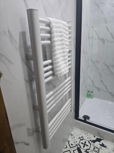a bathroom with a towel rack in front of a mirror at Aaron's Bothy in Portree