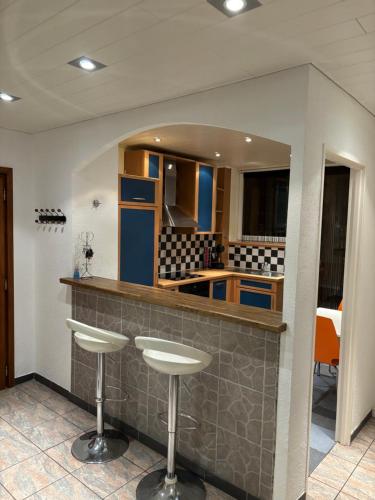 a kitchen with a counter with stools in it at Appartement des trois Frontières in Saint-Louis