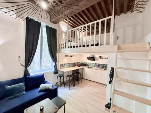 Cette chambre comprend un canapé bleu et une mezzanine. dans l'établissement Le Canut de L'Opéra - Hyper Centre de Lyon - Très Calme, à Lyon
