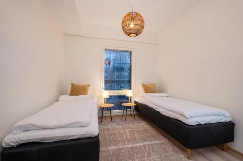 two beds in a room with a window at Brand New 2BDR with Private Sauna in Rovaniemi