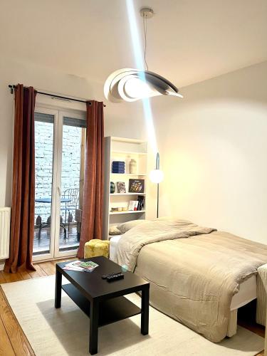 une chambre avec un lit, une table et une fenêtre dans l'établissement Magnifique & Cozy appartement au cœur de Strasbourg avec terrasse, à Strasbourg