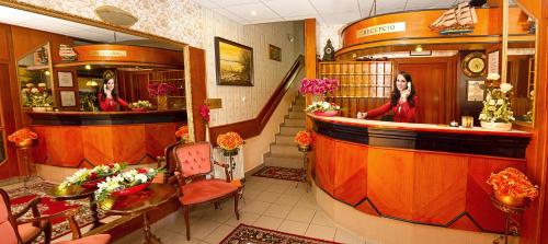 a woman standing at a bar in a hair salon at Hotel Wesselényi in Győr