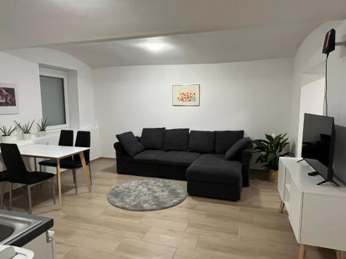a living room with a black couch and a table at Dahoam in Graz - Top1 in Graz