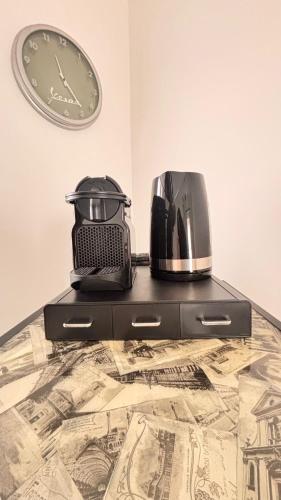 a clock on a wall next to a coffee maker on a dresser at Estilenuevo Fashion Rooms in Druento