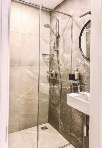 a bathroom with a shower and a sink at Kurortas Apartments in Palanga