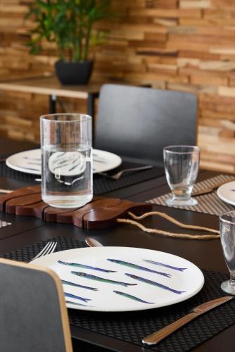 une table avec des assiettes et des verres au-dessus dans l'établissement Appartement Les Voiles de Mazy, Rue Calme à Sens Unique, à Pornichet