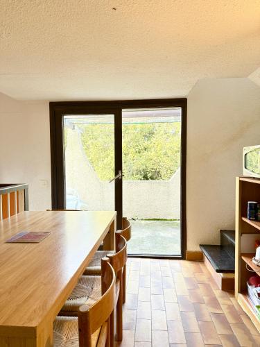 une salle à manger avec une table et une grande fenêtre dans l'établissement Maisonnette vue mer résidence vacances Porticcio, à Grosseto-Prugna