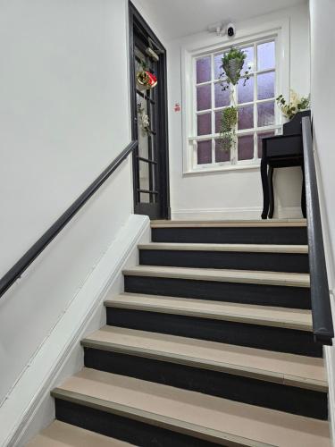a stairway with black and white stairs and a window at Central Chambers Suites - Suite 5 in Leek