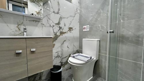 a bathroom with a toilet and a glass shower at Ρομαντικό Πέτρινο Διαμέρισμα για Ζευγάρια - Apt I in Chania Town