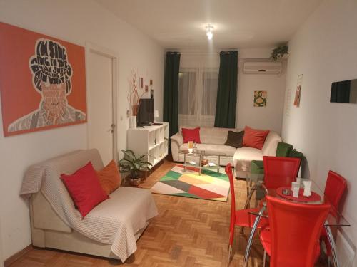 a living room with a couch and a table and chairs at Clockwork orange apartment in Vračar (historical)