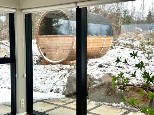a window view of a boat in the snow at The Glass house - Northern lights hideout in Mosfellsbær