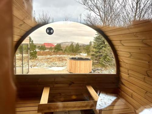 an arched window in a wooden room with a wooden table at The Glass house - Northern lights hideout in Mosfellsbær
