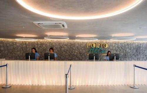 trois personnes assises à un comptoir avec leurs ordinateurs portables dans l'établissement GAV PORTO ALTO RESORT- Muro Alto, à Porto de Galinhas