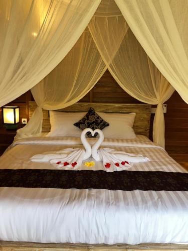 two swans made into hearts on a bed at Lumbung Kembar Sidemen in Sidemen
