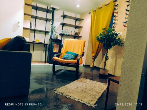 - un salon avec une chaise orange et un tapis dans l'établissement Maison de village cosy Céret, à Reynès