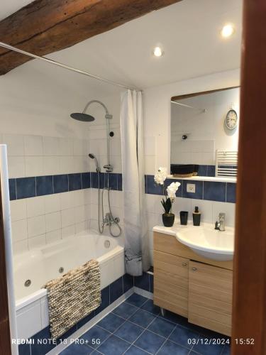une salle de bain avec une baignoire, un lavabo et un miroir dans l'établissement Maison de village cosy Céret, à Reynès
