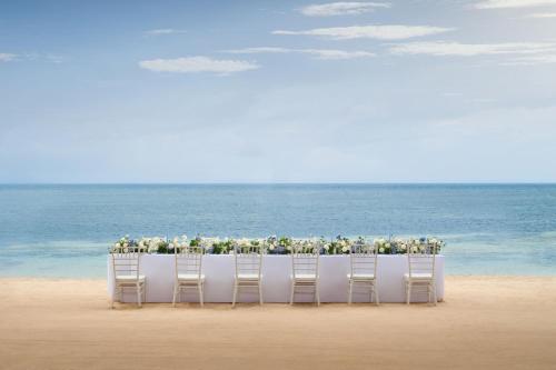a table on the beach with chairs and flowers at The Westin Resort Nusa Dua, Bali in Nusa Dua