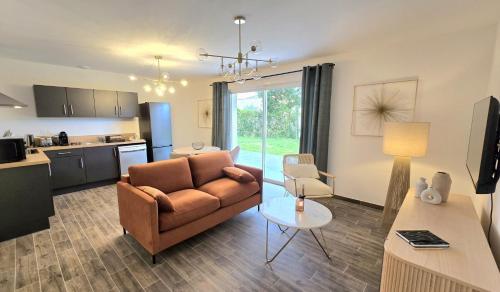 un salon avec un canapé et une cuisine dans l'établissement Résidence Au Cœur de Soi, à Jonzac
