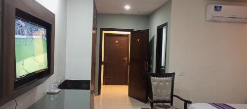 a room with a flat screen tv and a room with a room at Hira Guest House in Karachi