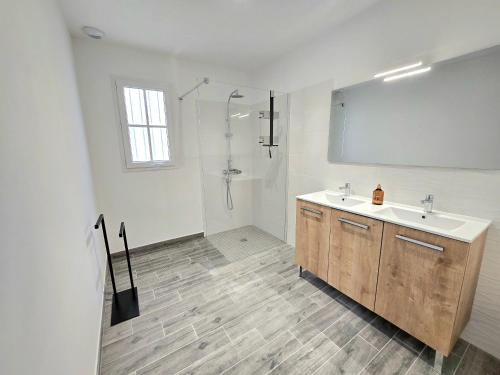 Un baño blanco con lavabo y ducha. en Résidence Au Cœur de Soi, en Jonzac