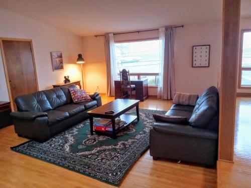 a living room with a leather couch and a table at Hotel Wolfe Island in Marysville