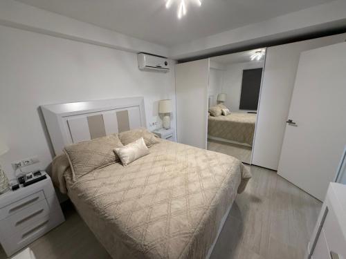 Un dormitorio pequeño con una cama y un espejo. en Apartamento Heliomar, en Málaga
