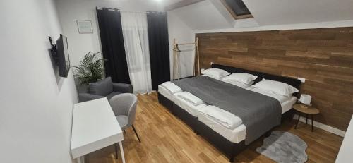 a bedroom with a large bed with a wooden headboard at Casa Adam B in Gara Ilişeşti
