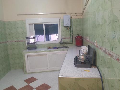 una cucina con piano di lavoro e finestra di شقة للكراء اليومي بمركز تنغير a Tinerhir