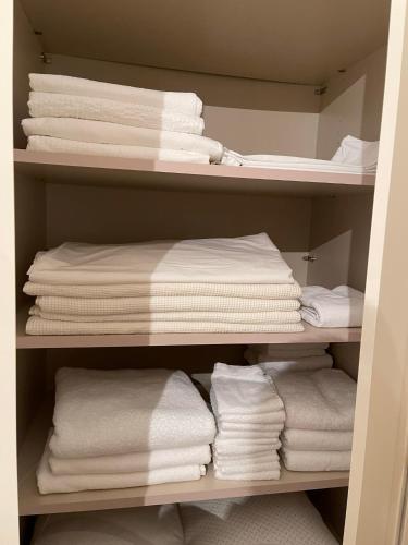 a closet filled with white towels on a shelf at BK Holiday in Rovinj