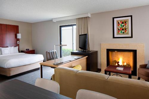 a hotel room with a bed and a fireplace at Residence Inn Dallas Las Colinas in Irving