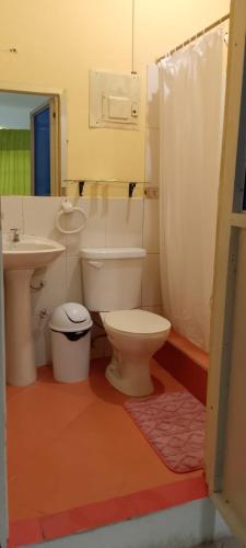 a bathroom with a toilet and a sink at Hostal La GRAN Familia in Manta