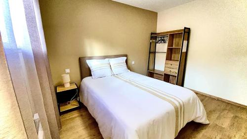 a bedroom with a large white bed in a room at Villa le Menhir 4 Ch au Bord du Lac et Terrasse in Villefranche-de-Panat
