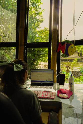 a woman sitting at a desk with a laptop computer at Bio Coliving Tayrona in Santa Marta