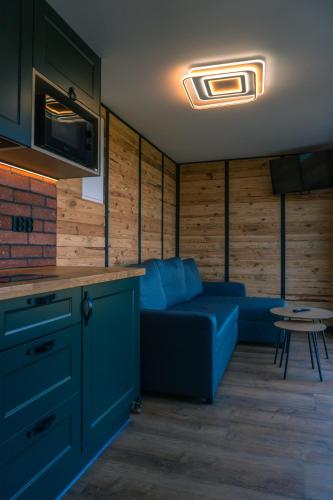 a living room with a blue couch and a table at Balia pod lasem in Stara Łomnica