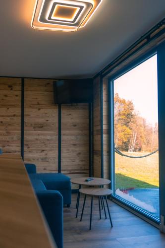 a living room with a table and a large window at Balia pod lasem in Stara Łomnica