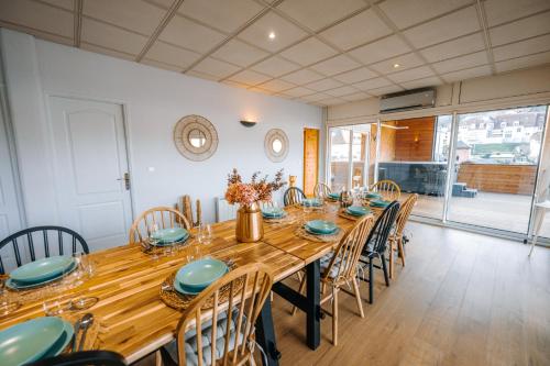 a dining room with a long wooden table and chairs at Le LOFT de la Route des Vins in Guebwiller