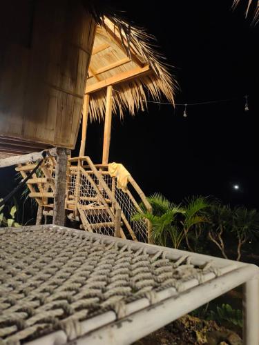 a bed with a keyboard in front of a hut at Tribu Kihud "Experience Simple Living" in Siquijor