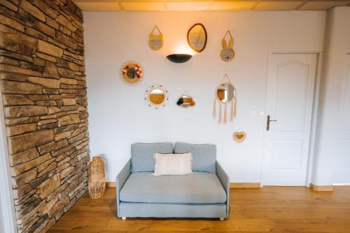 a room with a blue chair and a stone wall at Le LOFT de la Route des Vins in Guebwiller