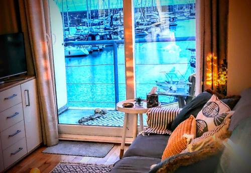 a living room with a window with a view of a harbor at The Boat View - Sea View - Tiny home Brighton Marina in Brighton & Hove