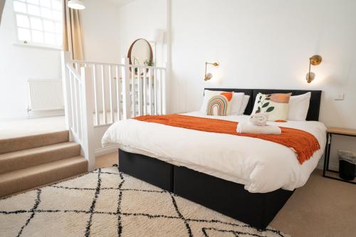 a bedroom with a large bed with an orange blanket at The Amazing Triplex - City Centre - Free Parking in Sheffield