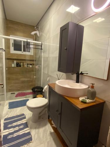 ein Badezimmer mit Waschbecken, Toilette und Dusche in der Unterkunft Casa aconchegante - Green Village - Praia do Cassino in Rio Grande