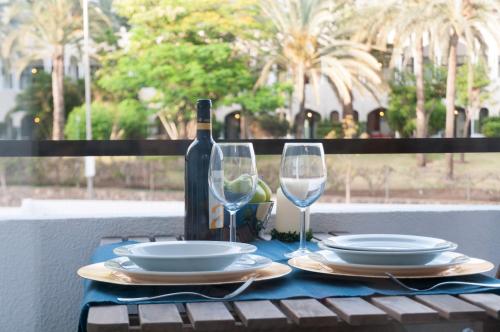 a table with a bottle of wine and two glasses at Prosurfing Apartamento in Playa del Ingles