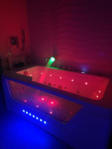 a bathroom with a tub with red and blue lights at New! Warsaw Luxury Apartment with Jacuzzi and total relax - Warszawski Luksus Jacuzzi i totalny relaks! in Warsaw