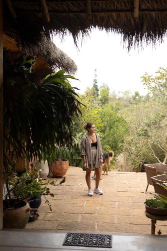 a woman standing on a patio with a dog at REFUGIO LA ROCA in Los Santos