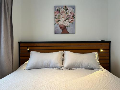 a bed with two pillows and a picture on the wall at Casona Italia B & B in Santiago