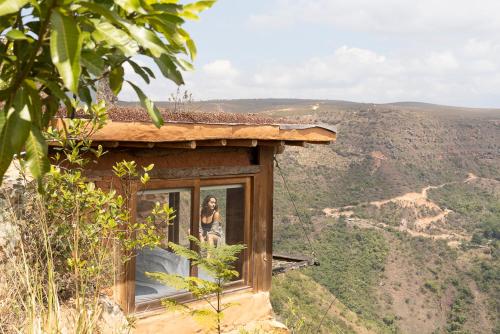 a woman is standing in a window of a house at REFUGIO LA ROCA in Los Santos