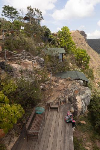 a wooden deck with two benches on a hill at REFUGIO LA ROCA in Los Santos