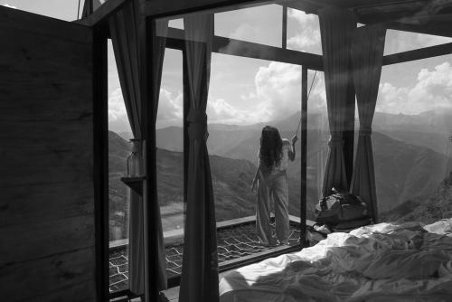 a girl looking out of a window at a mountain at REFUGIO LA ROCA in Los Santos